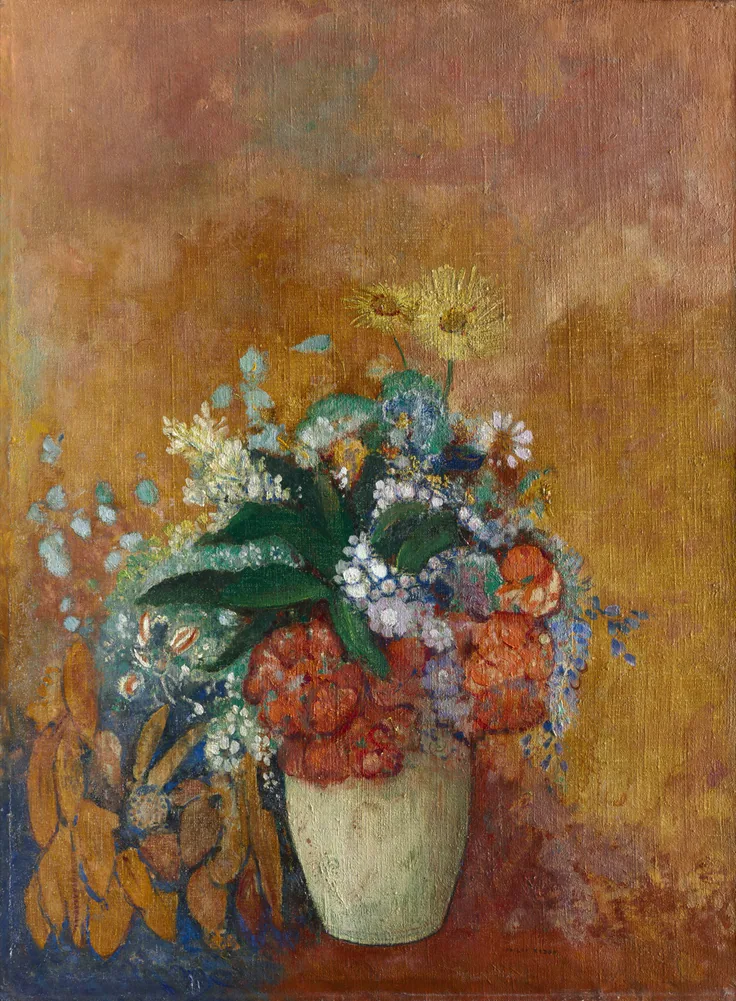 A dreamlike bouquet of red, blue and white flowers in a cream vase against a glowing ochre and rust background.