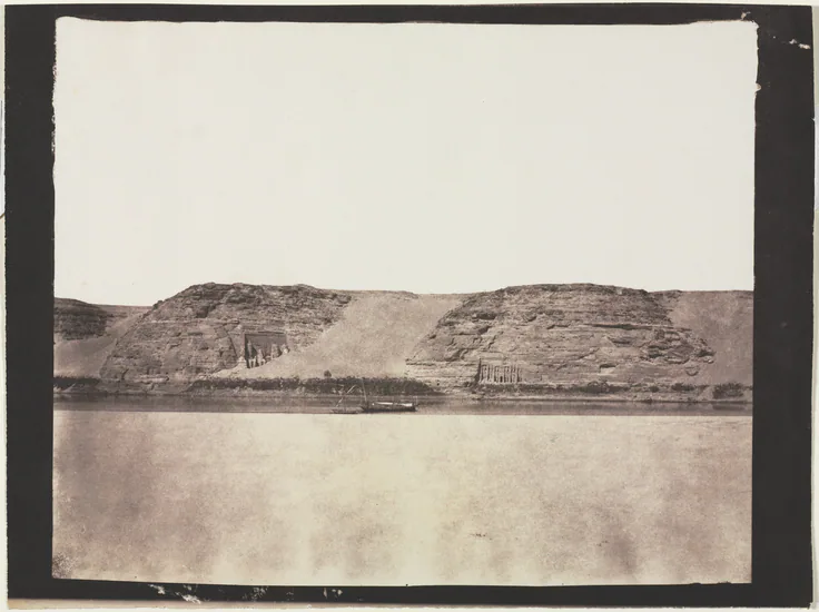 General View of Monuments Carved into Bedrock with Photographer's Dahabieh. Abu Simbel: salted paper print from a paper negative by Félix Teynard, 1851–1852.