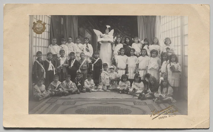Untitled (Semi-Circle of Children, Central Girl Dressed as an Angel Holding the Baby Jesus): gelatin silver print by Andrés and Francisco Hernández, c. 1910s.